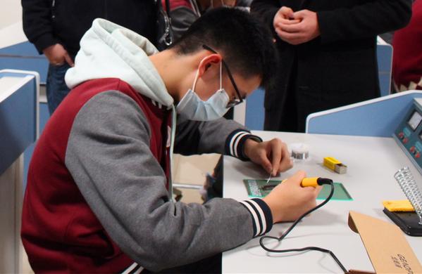 学生认真进行电路焊接