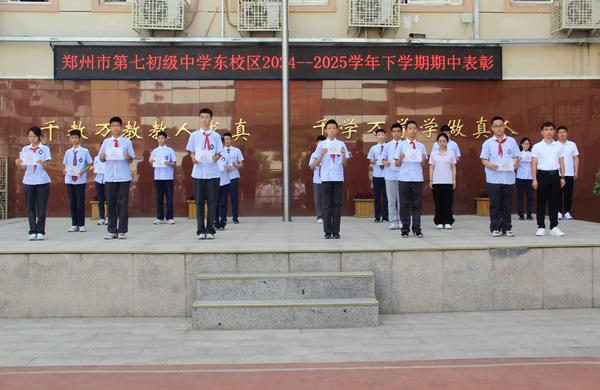 11郑州市第七初级中学东校区七年级管委会王志彦老师、八年级管委会周艺文老师、九年级管委会李敏宽老师为“年级单科状元”的学生颁发奖状